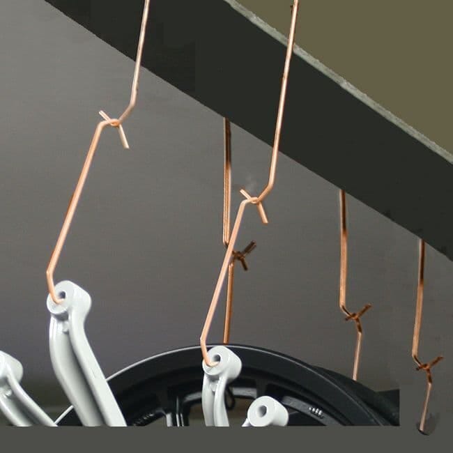 Technician loading masking hooks onto a powder coating rail
